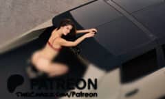 Young woman in red lingerie lying on car roof, looking up at camera from above.